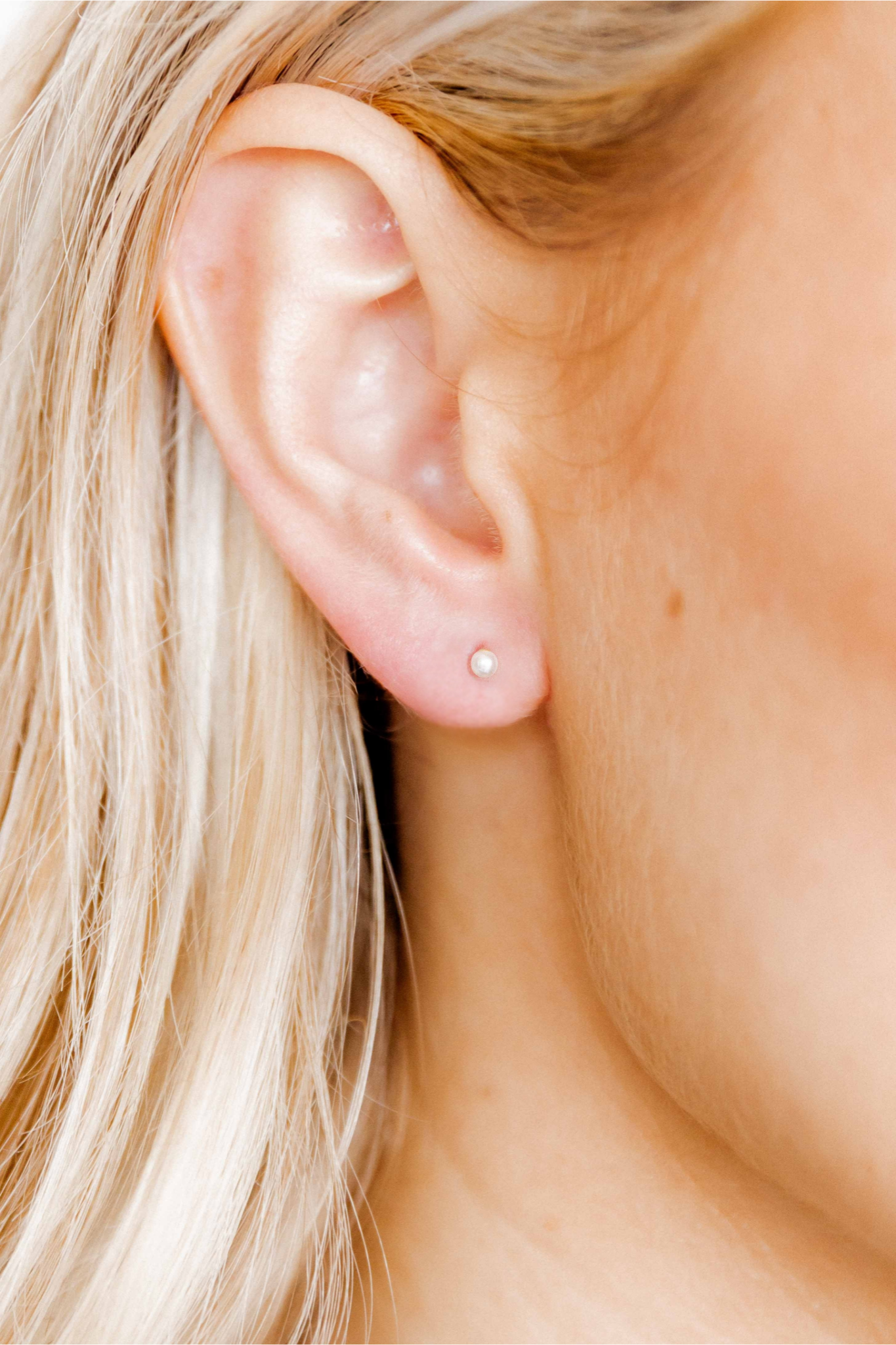 Close-up of an ear with a small Payton Pearl earring