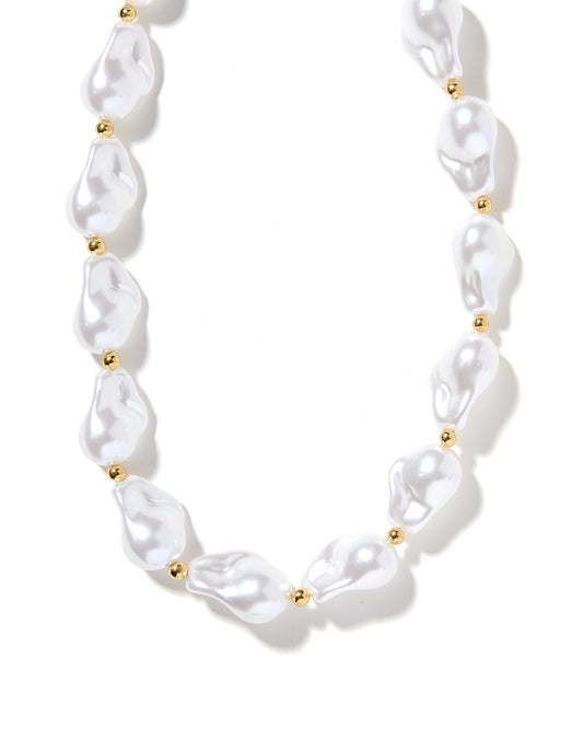 A white pearl necklace with gold beads and a gold toggle clasp, displayed on a plain background.