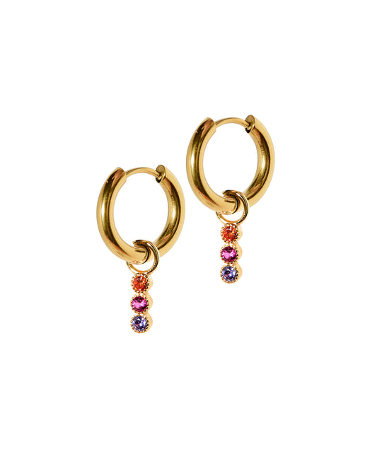 A pair of gold-colored huggie charm earrings featuring three vertical cubic zirconia stones in pink and purple colors.