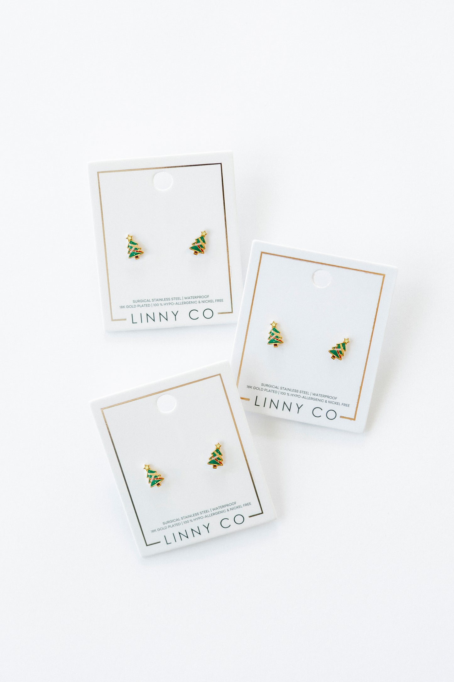 Three pairs of earrings on LINNY CO branded cards against a white background