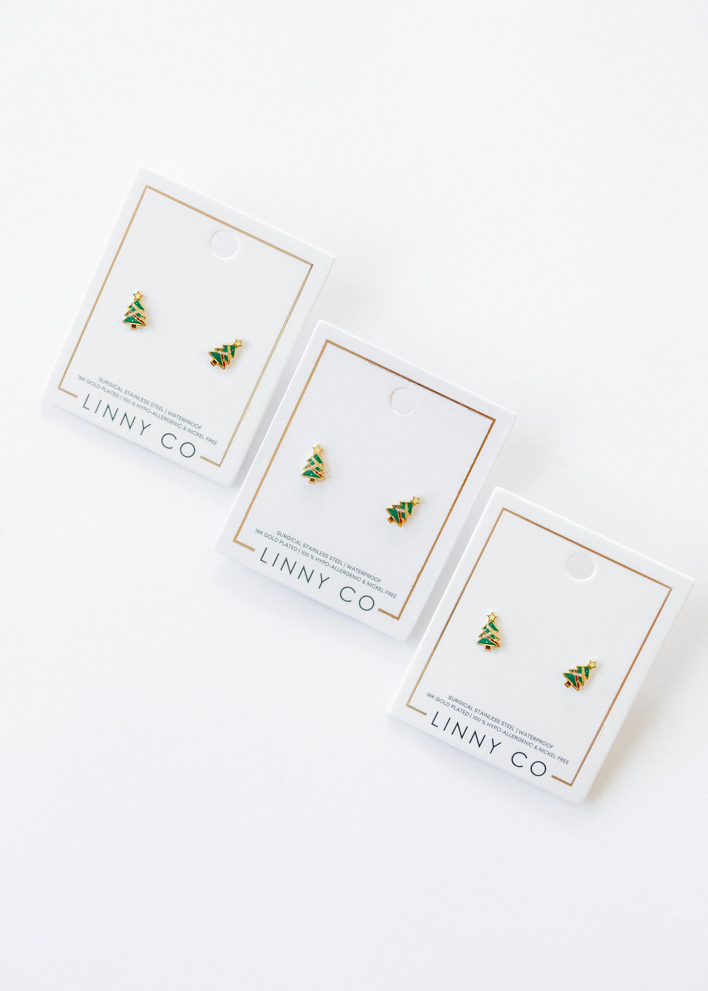 Three pairs of earrings on LINNY CO branded cards against a white background
