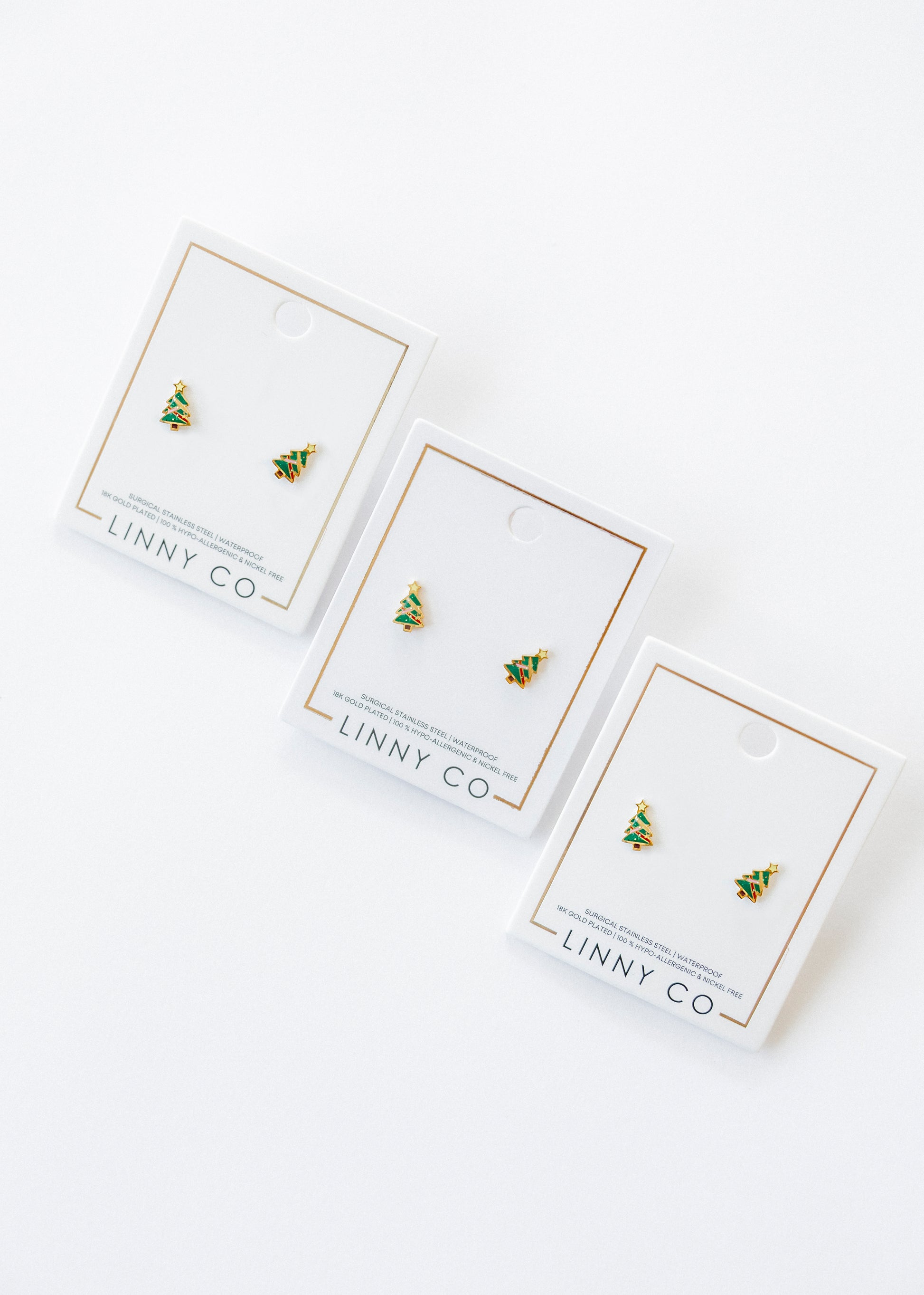 Three pairs of earrings on LINNY CO branded cards against a white background