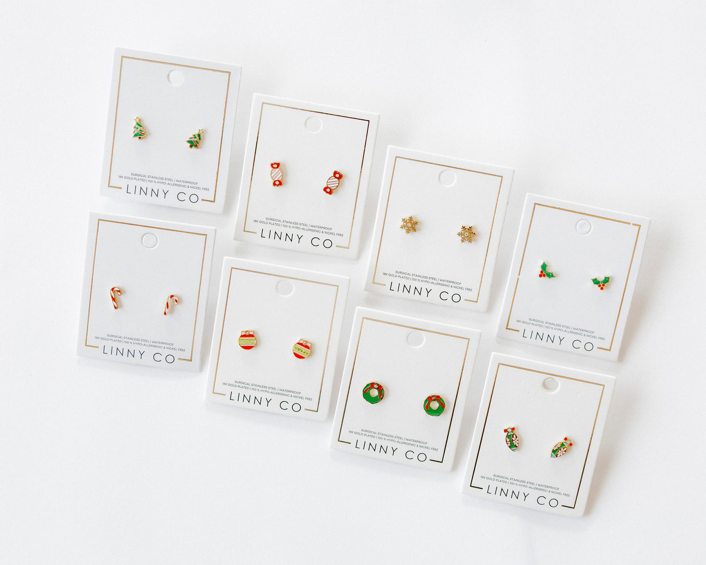 Set of small earrings on LINNY CO cards against a white background