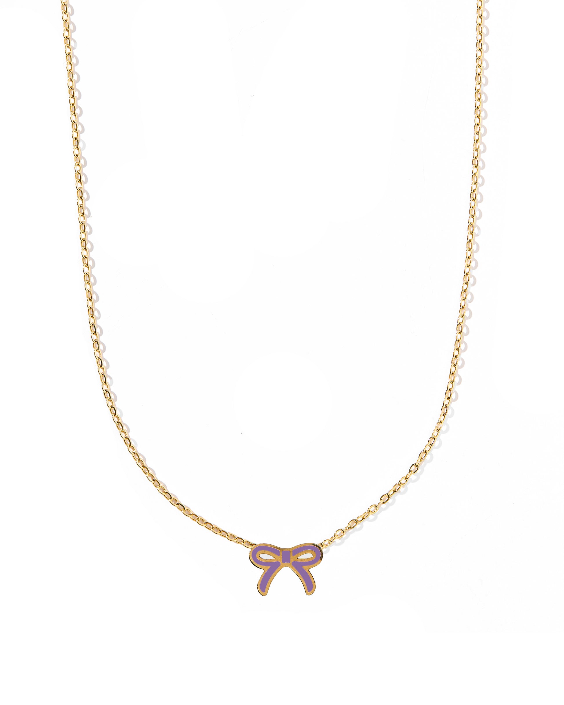 A thin gold bow pendant necklace with a purple accent on a white background.