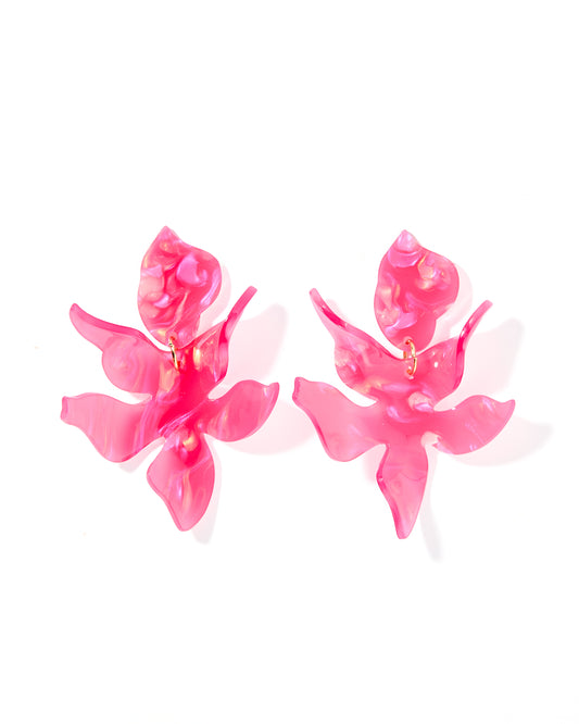 A pair of oversized pink statement earrings with a floral design.