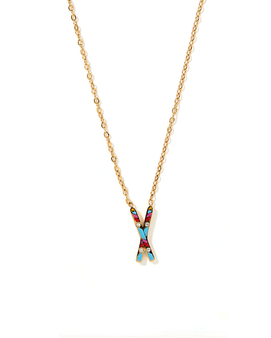 A gold-colored necklace with a multicolored snow ski pendant.
