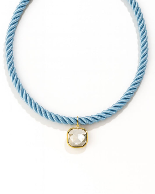 Light blue cord necklace with a clear stone pendant on a white background