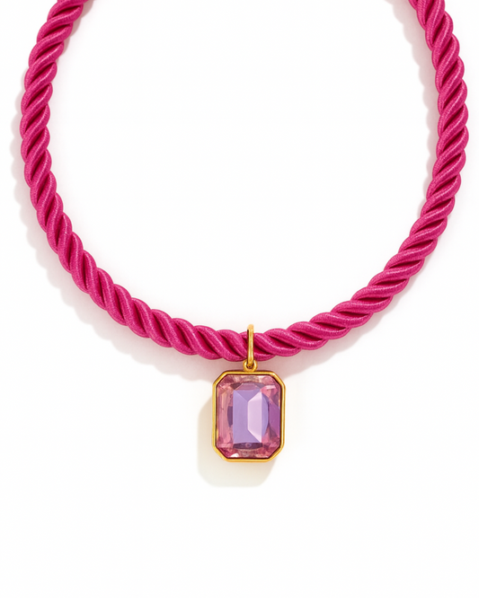 Pink rope necklace with a pink gemstone pendant on a white background