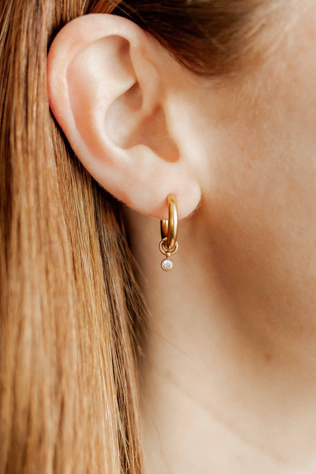 LINNY CO Celine Gold huggie earrings for kids & little girls — hypoallergenic, waterproof stainless steel, shown on model.