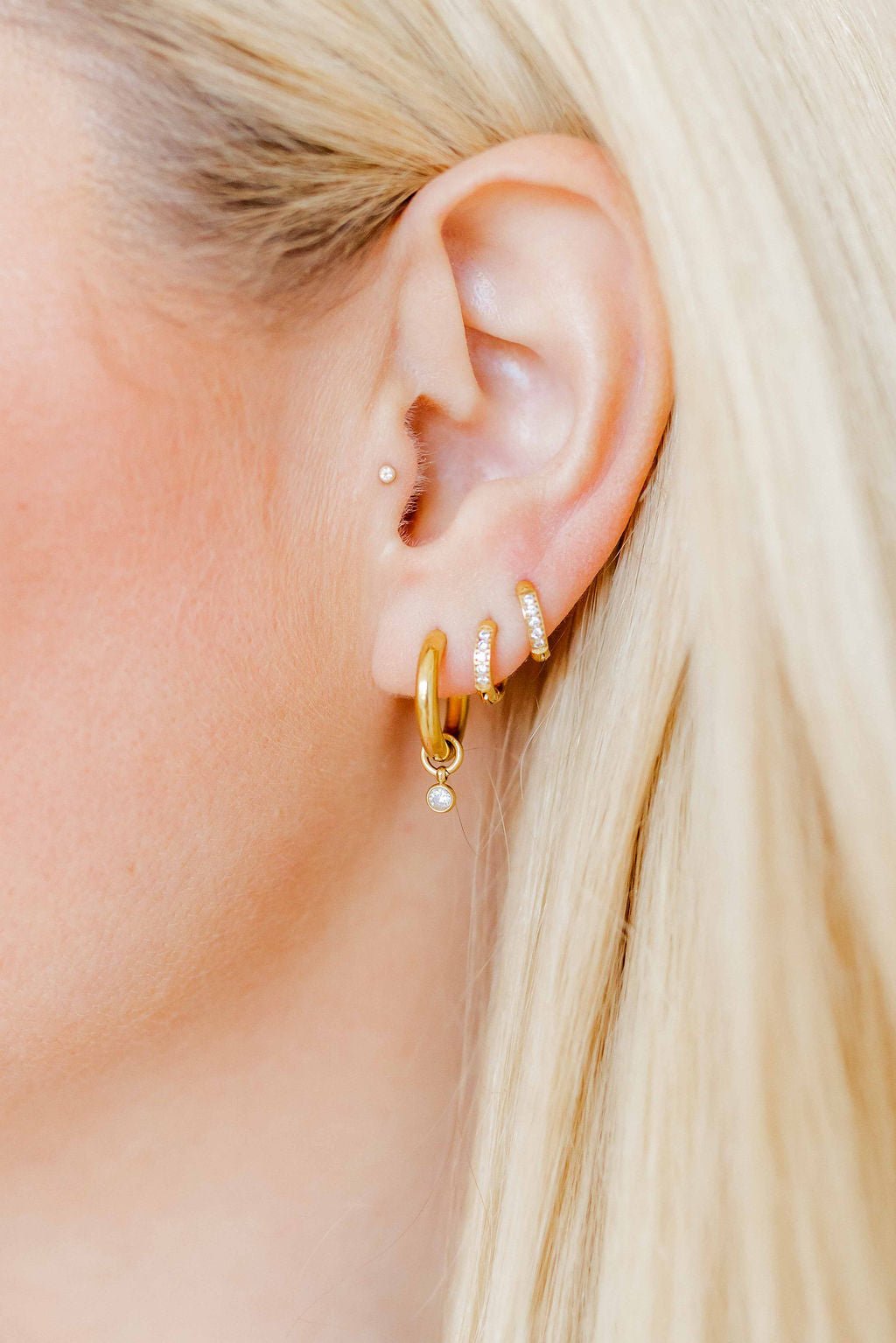 LINNY CO Celine Gold huggie earrings for kids & little girls — hypoallergenic, waterproof stainless steel, shown on model.