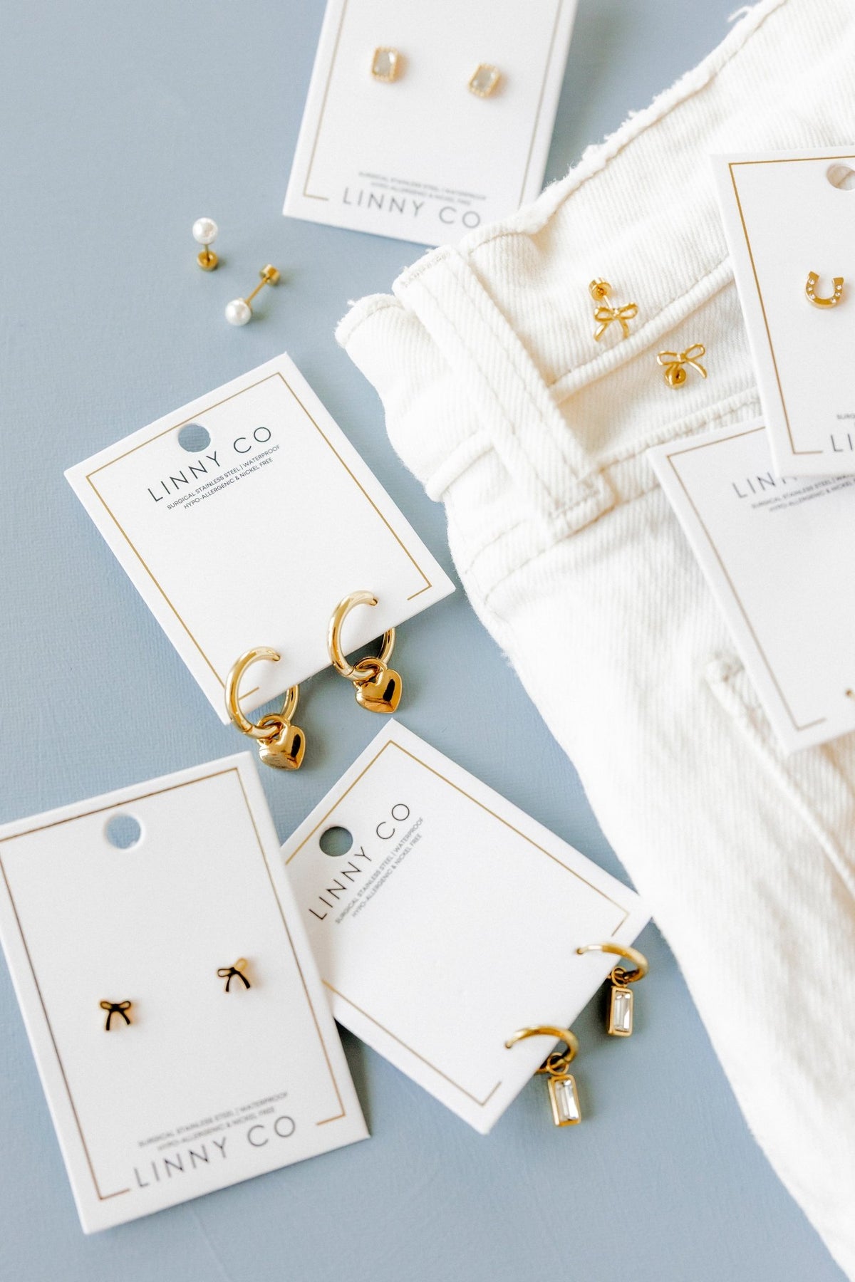 LINNY CO Dakota Heart huggie earrings for kids & little girls — hypoallergenic, waterproof stainless steel, flat-lay styling.