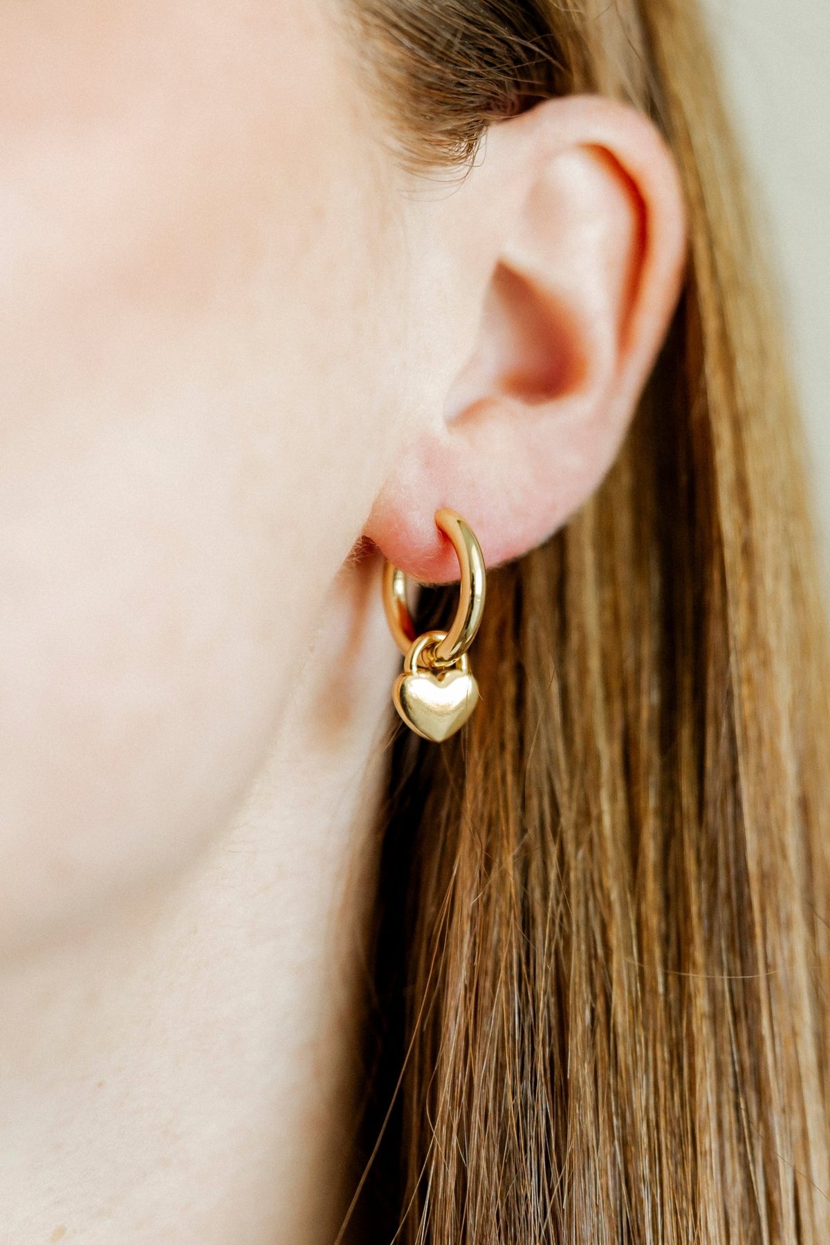 LINNY CO Dakota Heart huggie earrings for kids & little girls — hypoallergenic, waterproof stainless steel, shown on model.