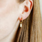 LINNY CO Edith Clear Gold huggie earrings for kids & little girls — hypoallergenic, waterproof stainless steel, shown on model.