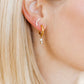 LINNY CO Jo Gold huggie earrings for kids & little girls — hypoallergenic, waterproof stainless steel, shown on model.