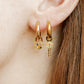 LINNY CO Lock and Key Gold huggie earrings for kids & little girls — hypoallergenic, waterproof stainless steel, shown on model.