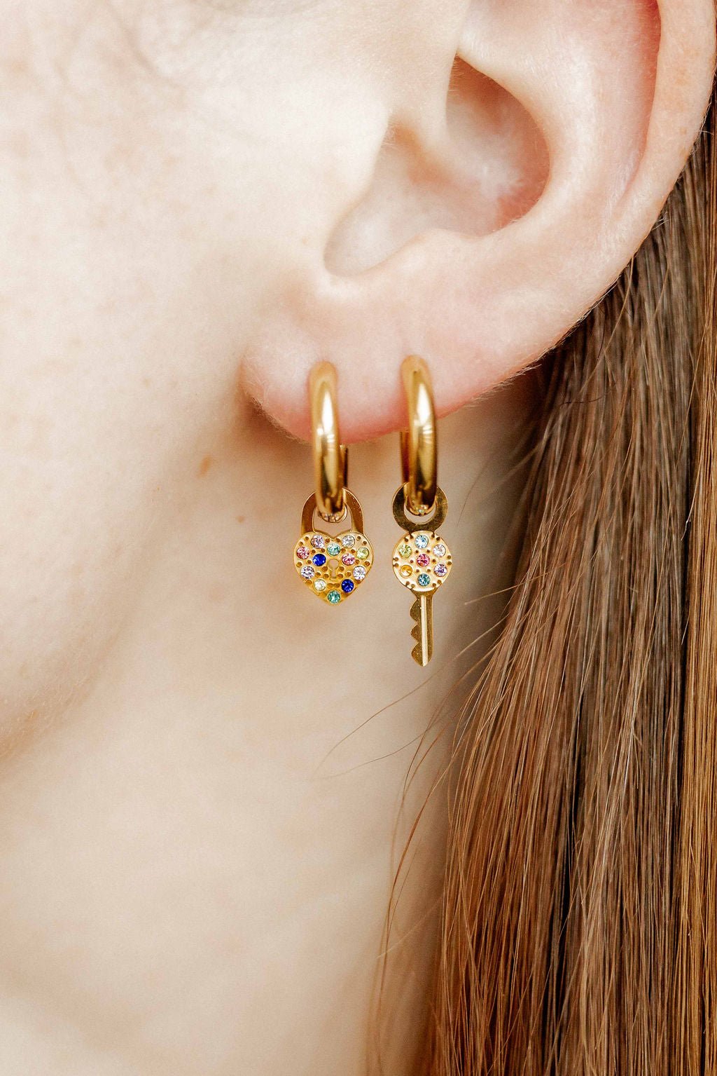 LINNY CO Lock and Key Gold huggie earrings for kids & little girls — hypoallergenic, waterproof stainless steel, shown on model.