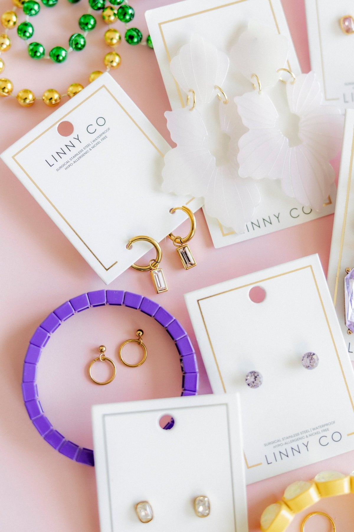 LINNY CO Nola 8mm huggie earrings for kids & little girls — hypoallergenic, waterproof stainless steel, flat-lay styling.
