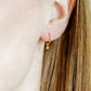 LINNY CO Nola 8mm huggie earrings for kids & little girls — hypoallergenic, waterproof stainless steel, shown on model.