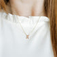 LINNY CO Breast Cancer Ribbon necklace for kids & little girls — hypoallergenic, waterproof stainless steel, shown on model.