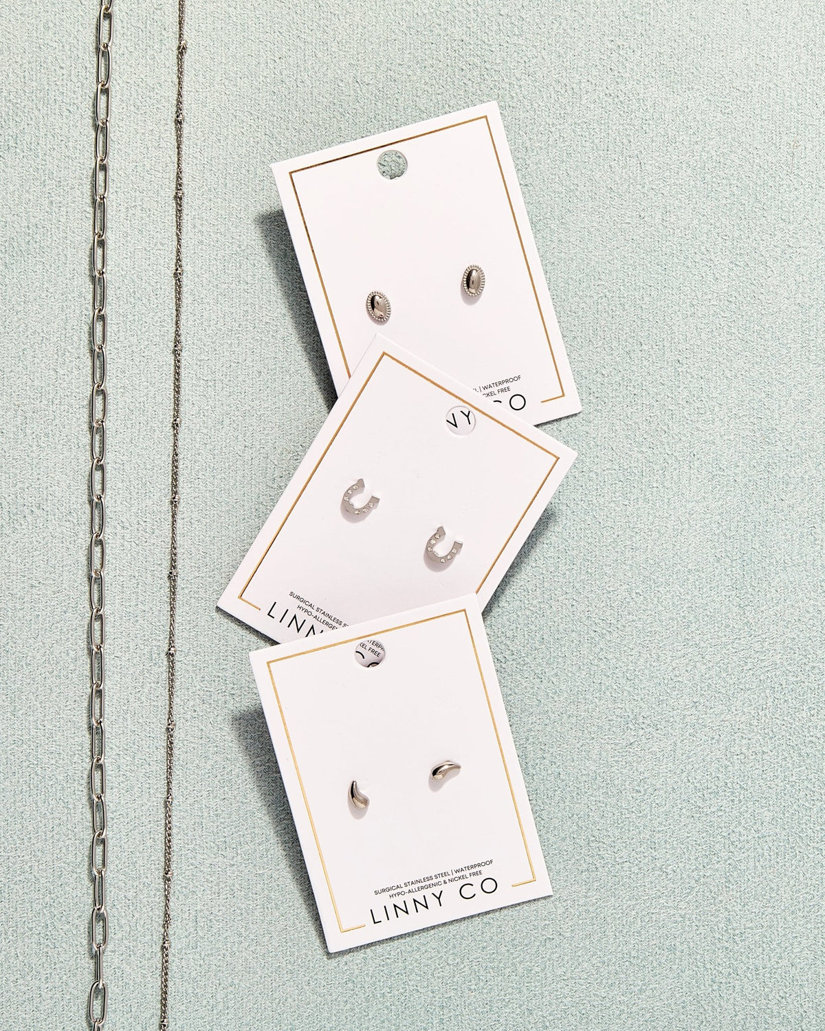 LINNY CO Miles Silver necklace for kids & little girls — hypoallergenic, waterproof stainless steel, flat-lay styling.