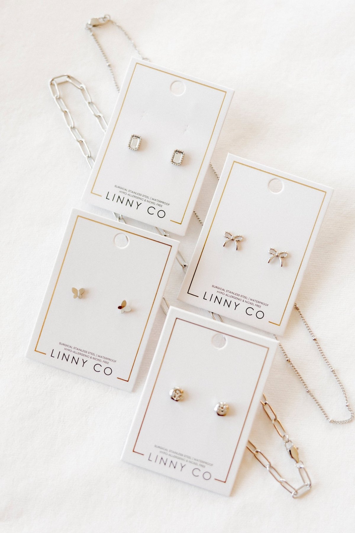 LINNY CO Miles Silver necklace for kids & little girls — hypoallergenic, waterproof stainless steel, flat-lay styling.