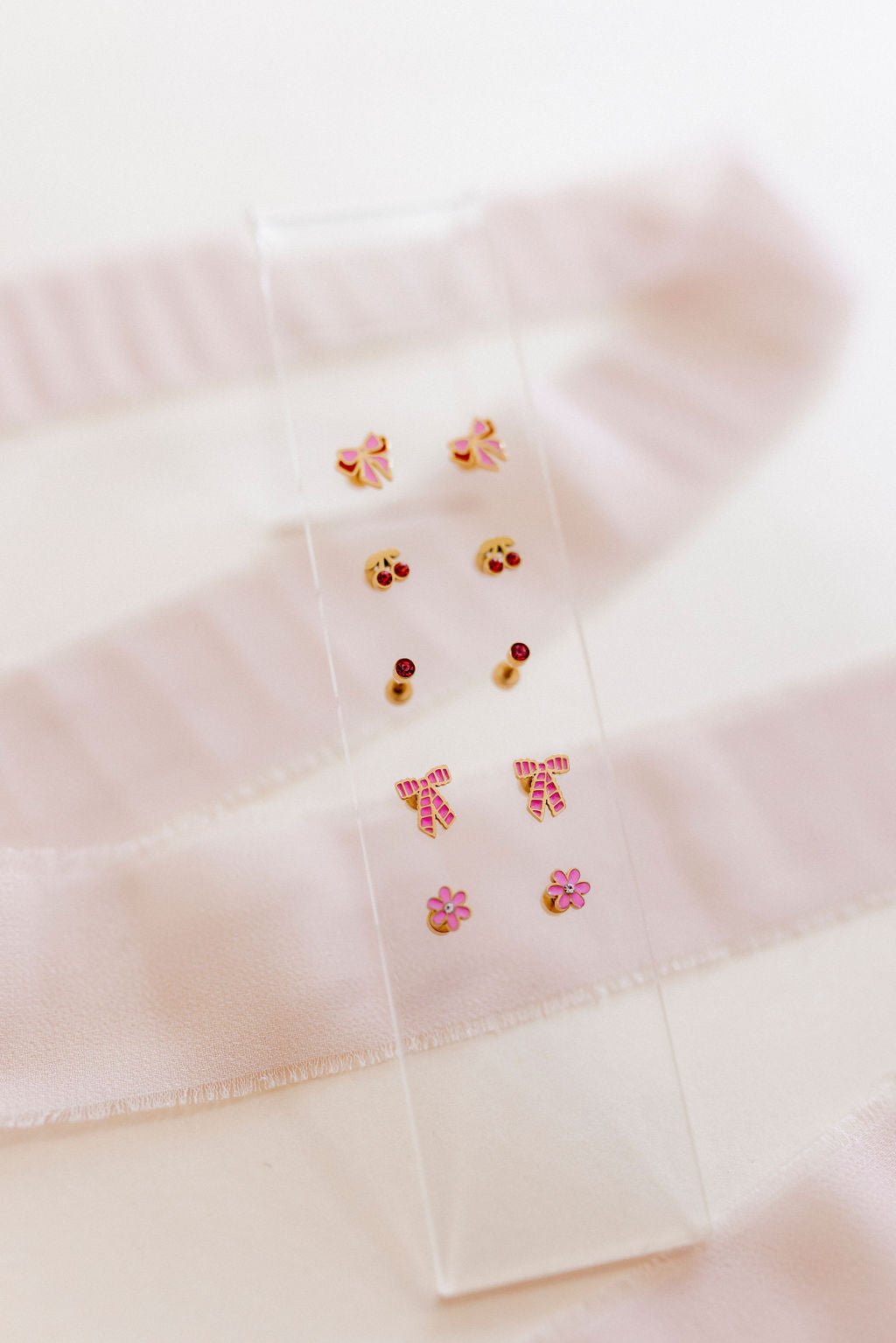 LINNY CO Alli Pink screwback stud earrings for kids & little girls — hypoallergenic, waterproof stainless steel with secure screwback backs, flat-lay styling.