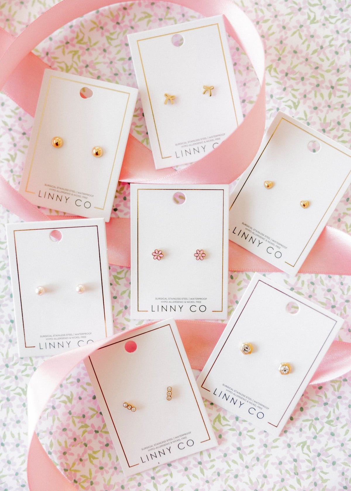 LINNY CO Alli Pink screwback stud earrings for kids & little girls — hypoallergenic, waterproof stainless steel with secure screwback backs, flat-lay styling.