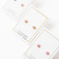 LINNY CO Alli Pink screwback stud earrings for kids & little girls — hypoallergenic, waterproof stainless steel with secure screwback backs, flat-lay styling.