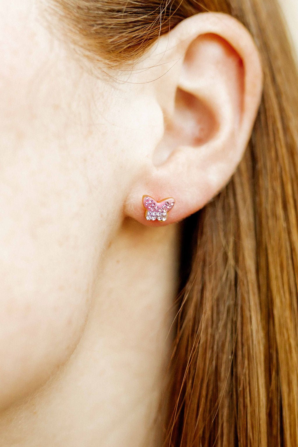 LINNY CO Bindi Butterfly screwback stud earrings for kids & little girls — hypoallergenic, waterproof stainless steel with secure screwback backs, shown on model.
