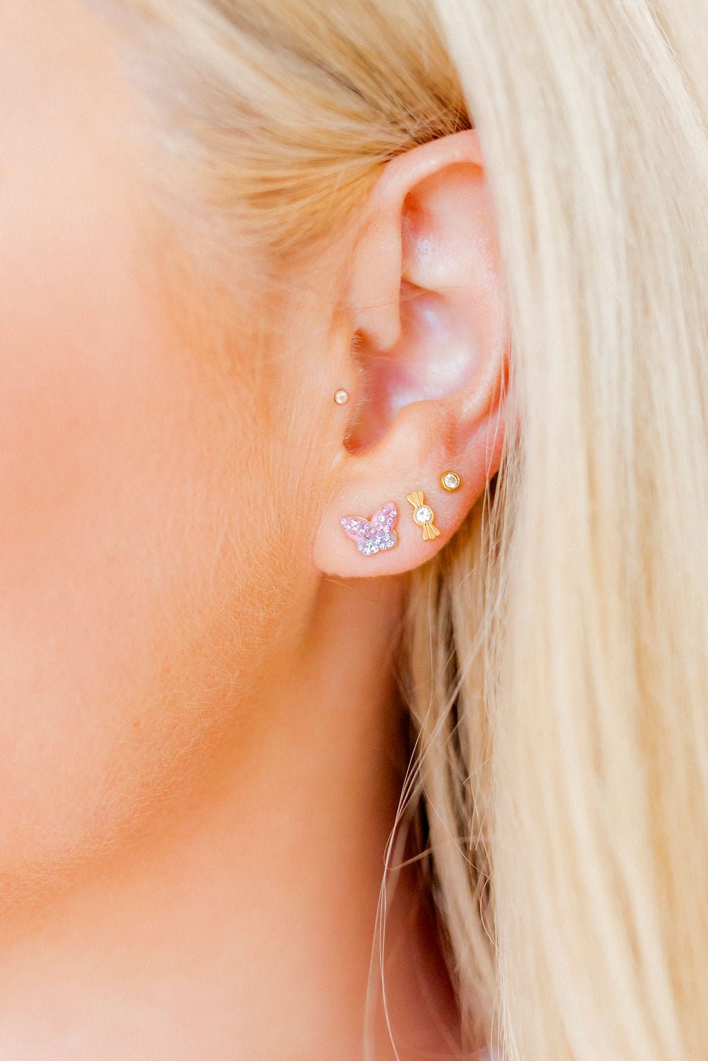 LINNY CO Bindi Butterfly screwback stud earrings for kids & little girls — hypoallergenic, waterproof stainless steel with secure screwback backs, shown on model.