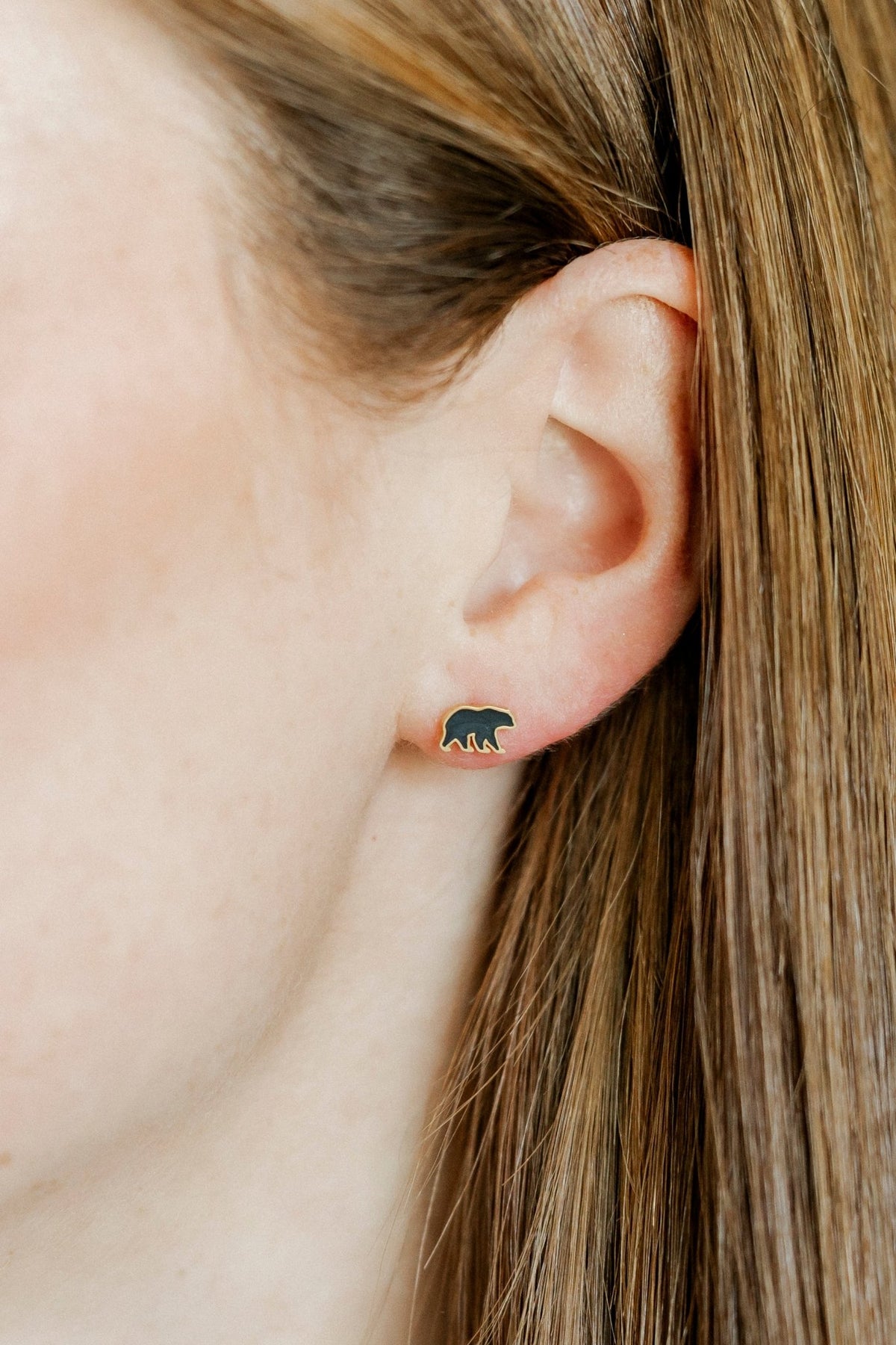 LINNY CO Black Bear screwback stud earrings for kids & little girls — hypoallergenic, waterproof stainless steel with secure screwback backs, shown on model.