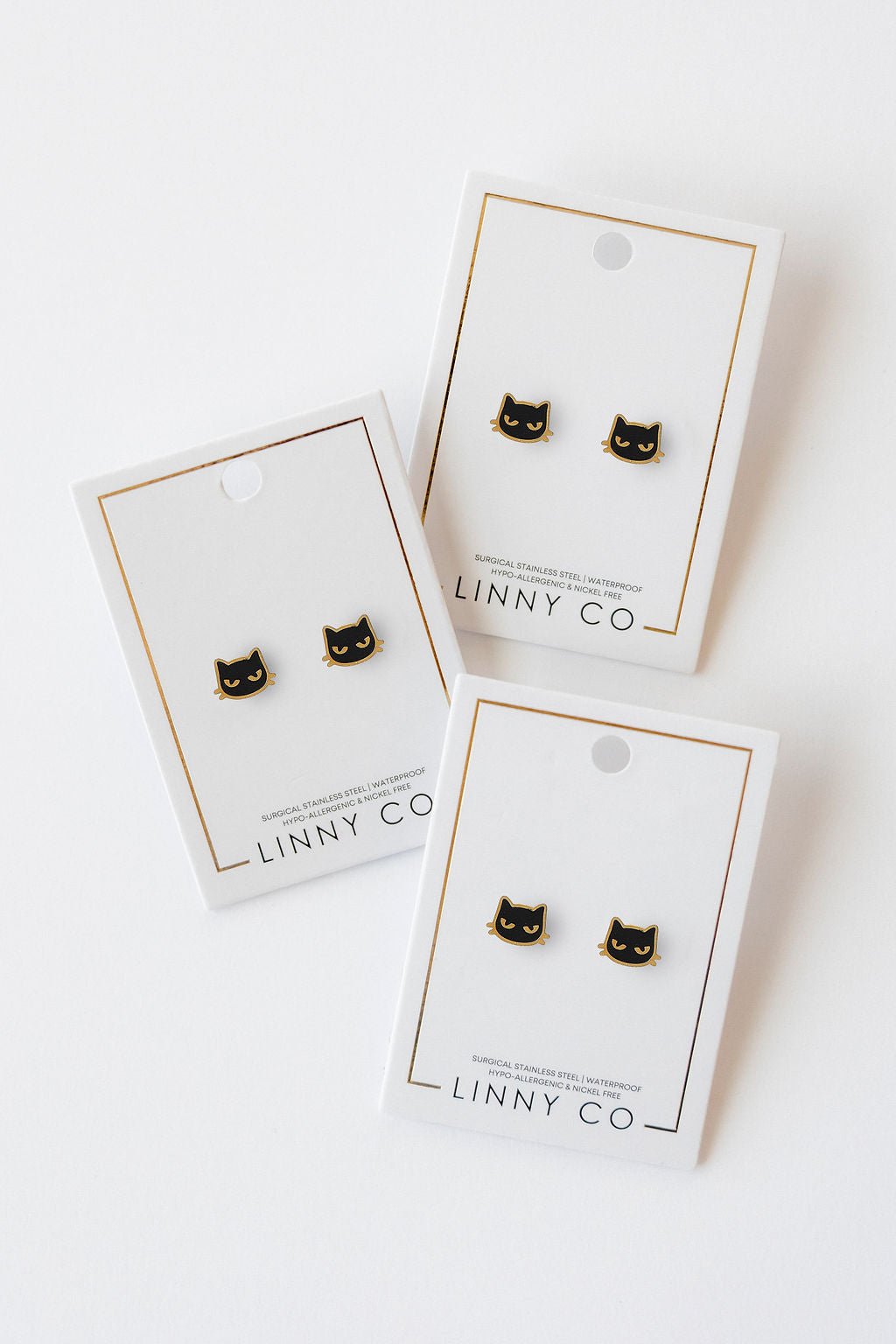 LINNY CO Black Cat screwback stud earrings for kids & little girls — hypoallergenic, waterproof stainless steel with secure screwback backs, flat-lay styling.