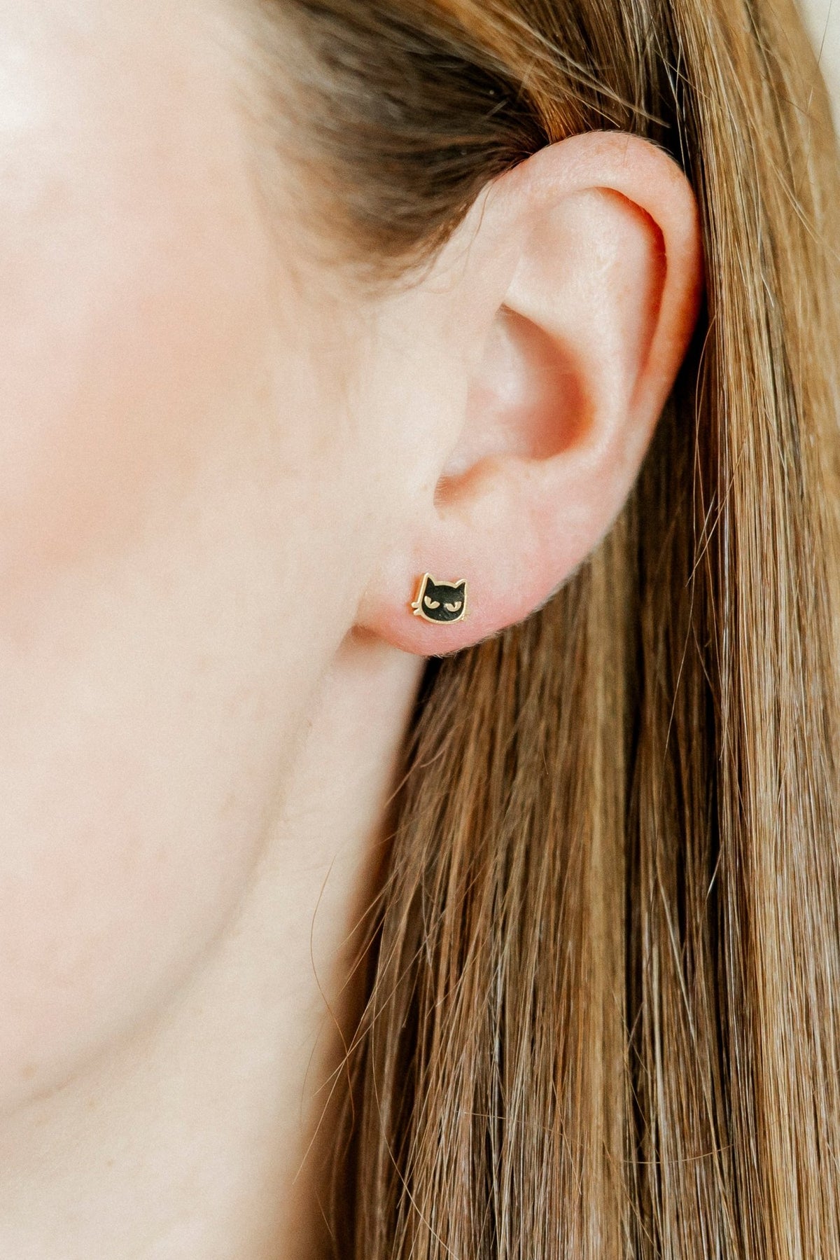 LINNY CO Black Cat screwback stud earrings for kids & little girls — hypoallergenic, waterproof stainless steel with secure screwback backs, shown on model.