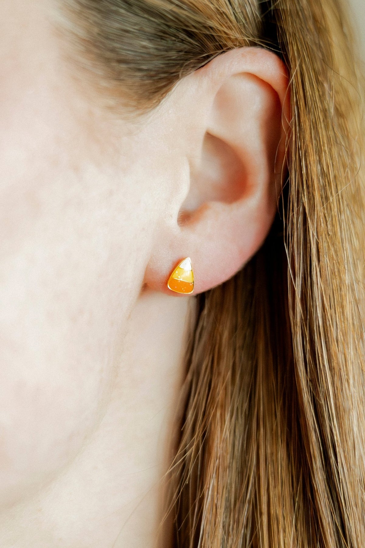 LINNY CO Candy Corn screwback stud earrings for kids & little girls — hypoallergenic, waterproof stainless steel with secure screwback backs, shown on model.