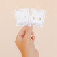 LINNY CO Catherine Cross Gold screwback stud earrings — hypoallergenic, waterproof stainless steel, in packaging.