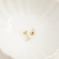 LINNY CO Clara Cross Gold Sparkle screwback stud earrings — hypoallergenic, waterproof stainless steel, flat-lay styling.