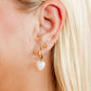 LINNY CO Clara Cross Gold Sparkle screwback stud earrings — hypoallergenic, waterproof stainless steel, shown on model.