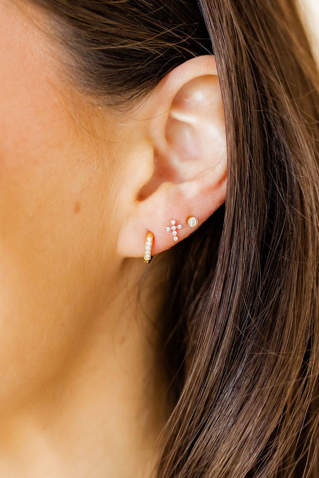 LINNY CO Clara Cross Gold Sparkle screwback stud earrings — hypoallergenic, waterproof stainless steel, shown on model.