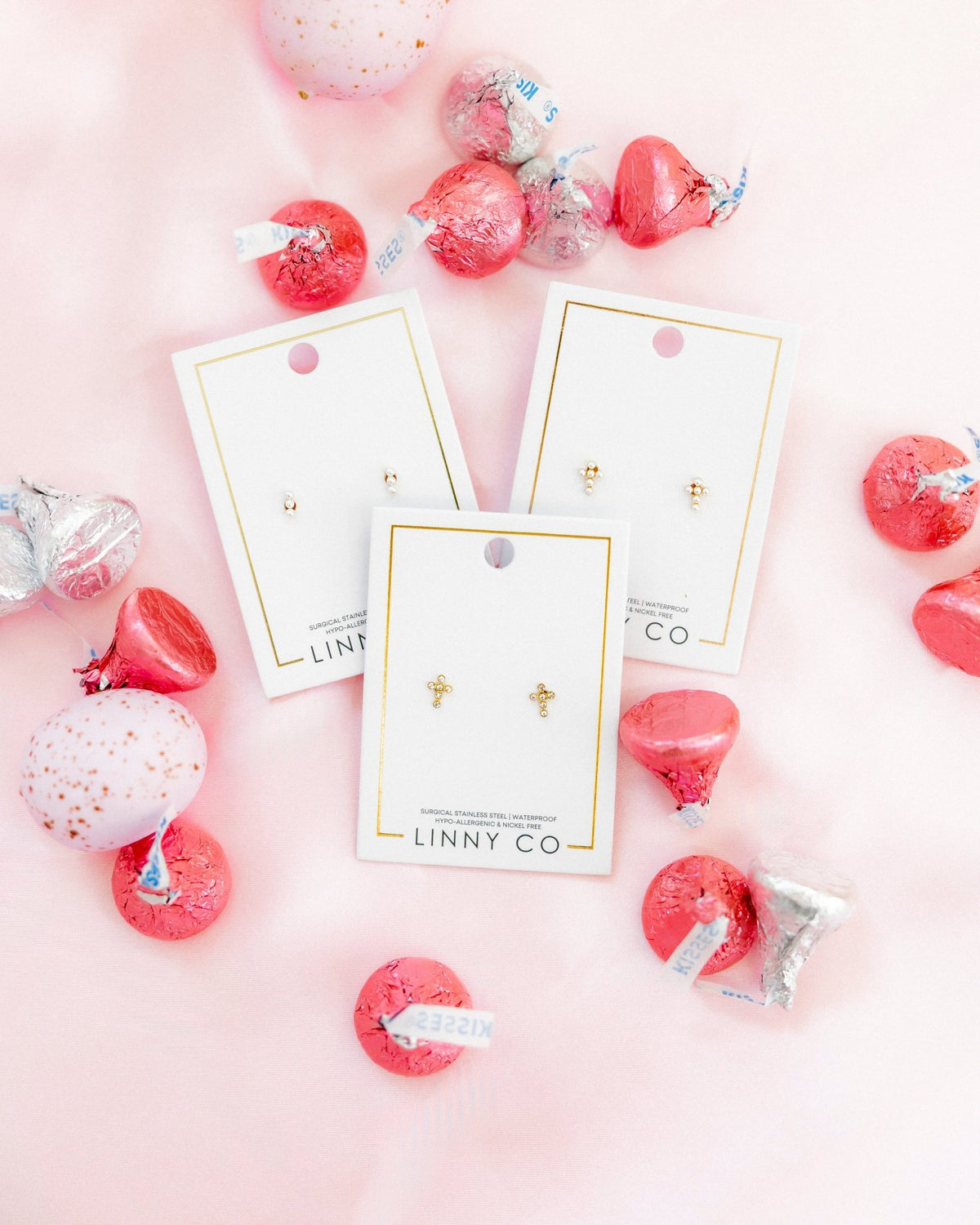 LINNY CO Clara Cross Pearl screwback stud earrings for kids & little girls — hypoallergenic, waterproof stainless steel with secure screwback backs, flat-lay styling.