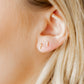 LINNY CO Clara Cross Pearl screwback stud earrings for kids & little girls — hypoallergenic, waterproof stainless steel with secure screwback backs, shown on model.