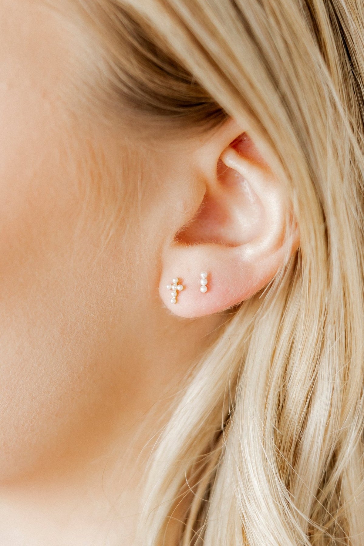 LINNY CO Clara Cross Pearl screwback stud earrings for kids & little girls — hypoallergenic, waterproof stainless steel with secure screwback backs, shown on model.