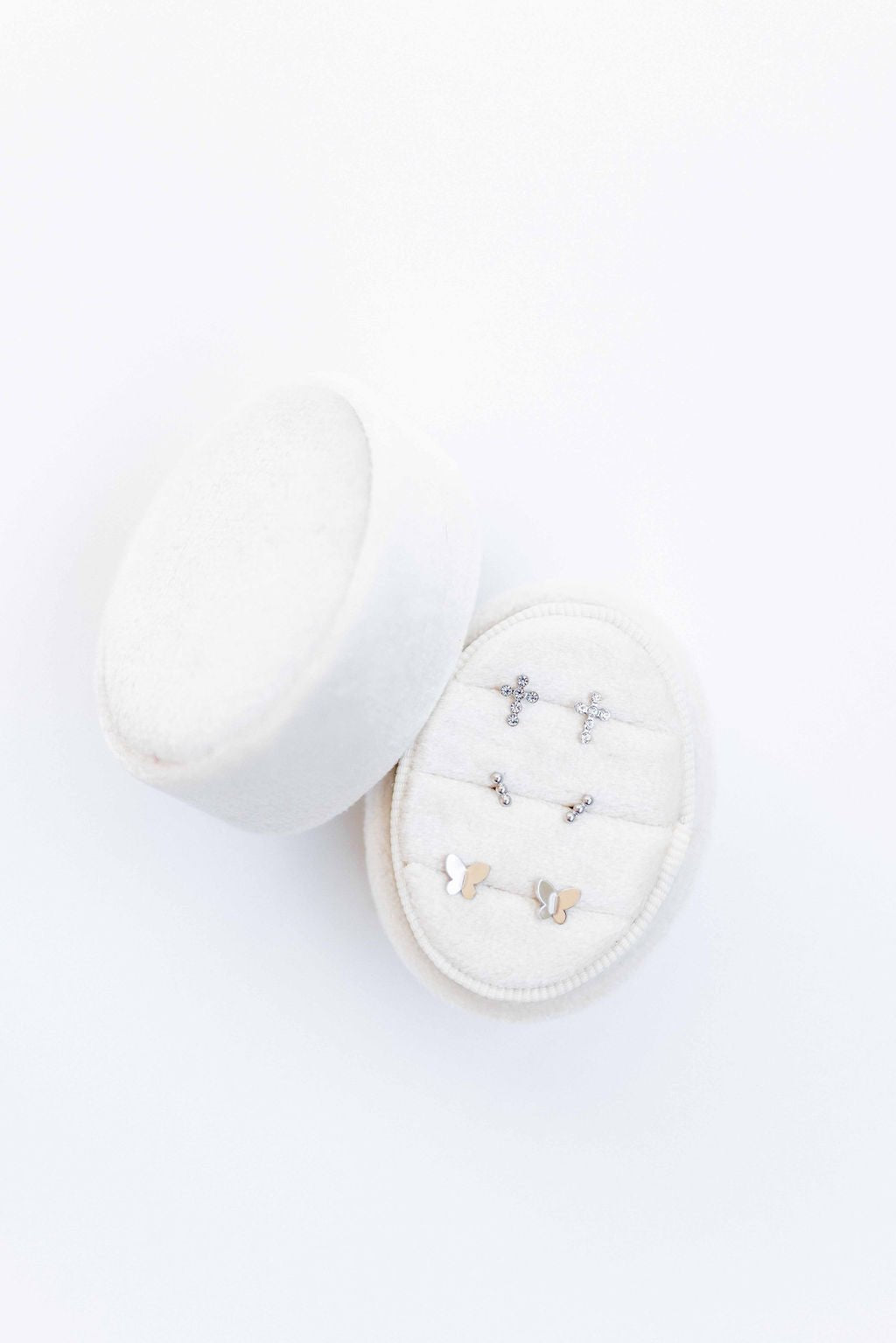 LINNY CO Clara Cross Silver Sparkle screwback stud earrings for kids & little girls — hypoallergenic, waterproof stainless steel with secure screwback backs, flat-lay styling.
