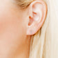 LINNY CO Clara Cross Silver Sparkle screwback stud earrings for kids & little girls — hypoallergenic, waterproof stainless steel with secure screwback backs, shown on model.