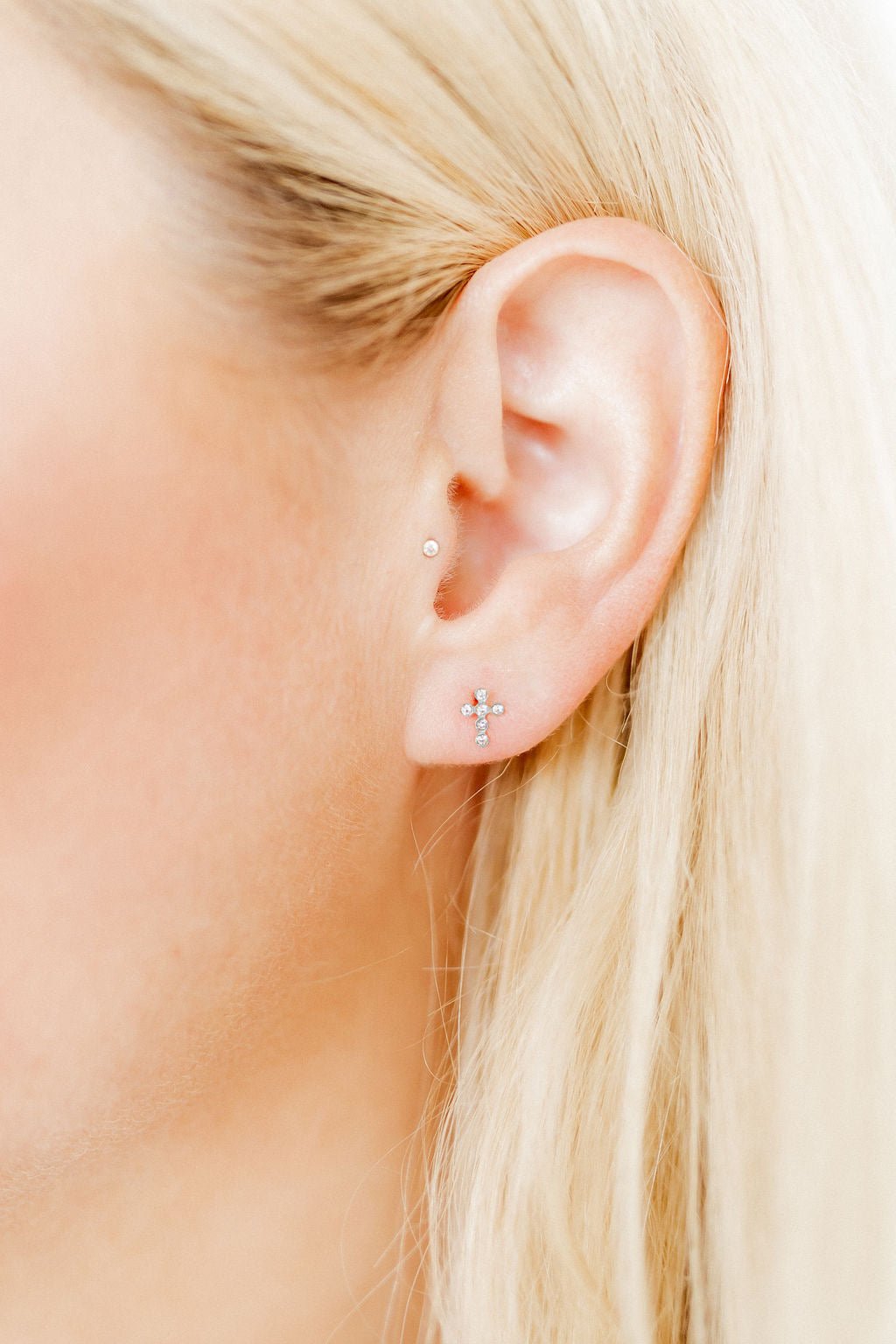 LINNY CO Clara Cross Silver Sparkle screwback stud earrings for kids & little girls — hypoallergenic, waterproof stainless steel with secure screwback backs, shown on model.