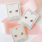 LINNY CO Collins Bow screwback stud earrings for kids & little girls — hypoallergenic, waterproof stainless steel with secure screwback backs, flat-lay styling.