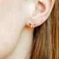 LINNY CO Collins Bow screwback stud earrings for kids & little girls — hypoallergenic, waterproof stainless steel with secure screwback backs, shown on model.