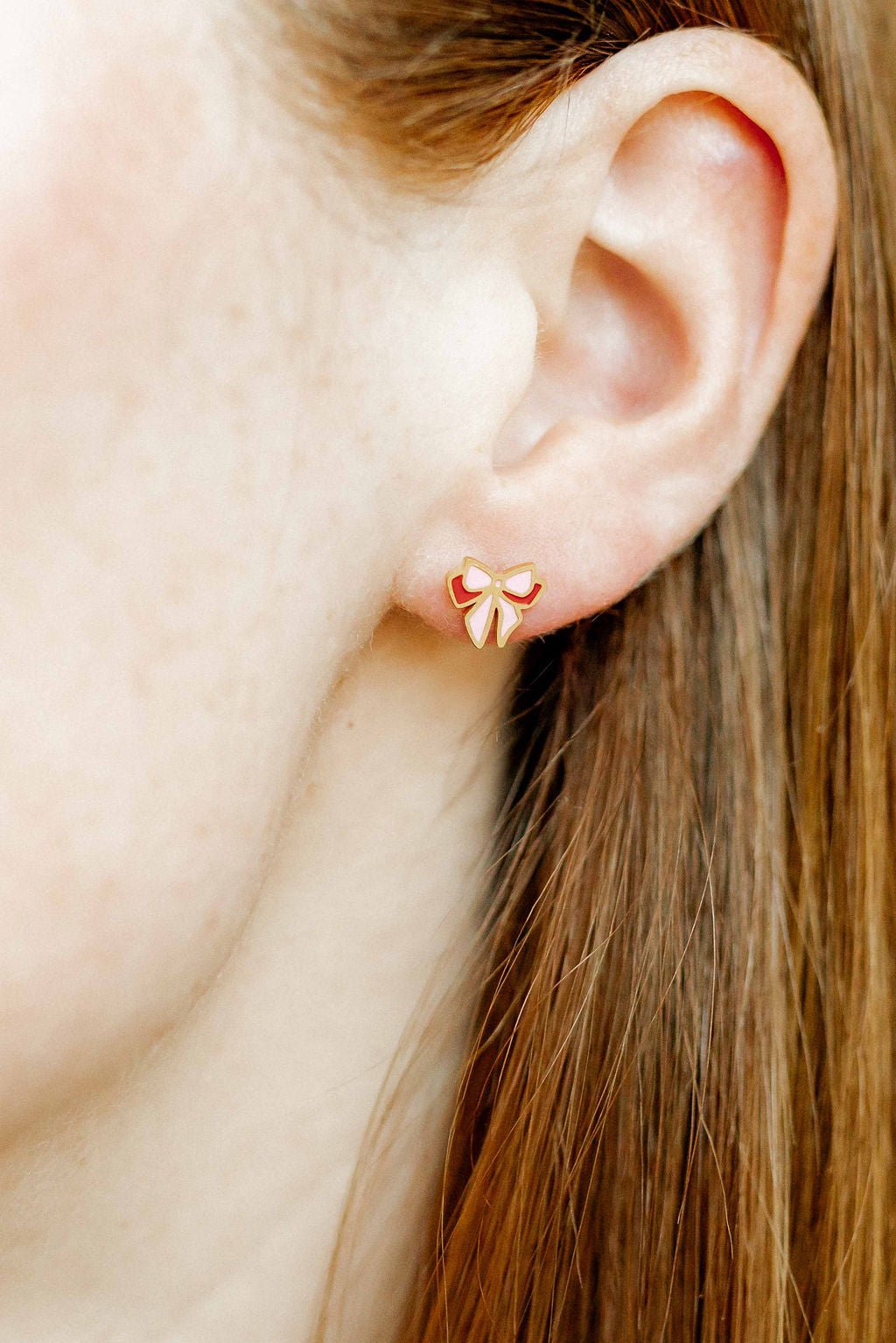 LINNY CO Collins Bow screwback stud earrings for kids & little girls — hypoallergenic, waterproof stainless steel with secure screwback backs, shown on model.
