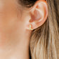LINNY CO Daisy Cowgirl Boot Gold screwback stud earrings for kids & little girls — hypoallergenic, waterproof stainless steel with secure screwback backs, shown on model.