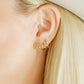 LINNY CO Daisy Cowgirl Boot Gold screwback stud earrings for kids & little girls — hypoallergenic, waterproof stainless steel with secure screwback backs, shown on model.