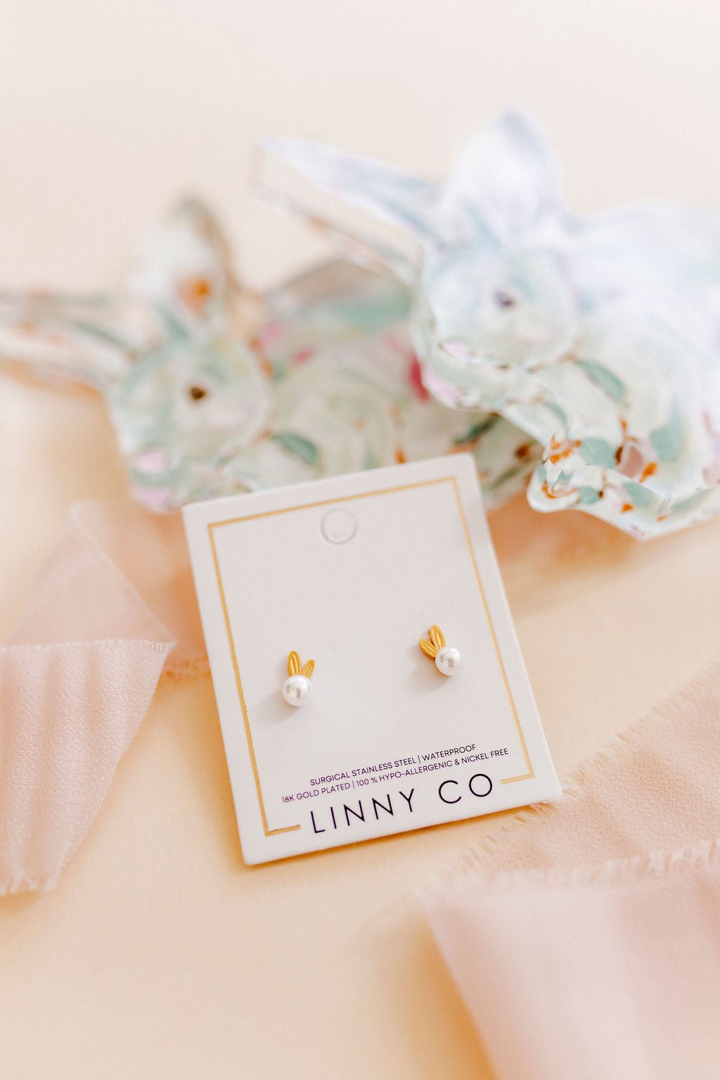 LINNY CO Heidi Pearl Bunny screwback stud earrings for kids & little girls — hypoallergenic, waterproof stainless steel with secure screwback backs, shown on model.